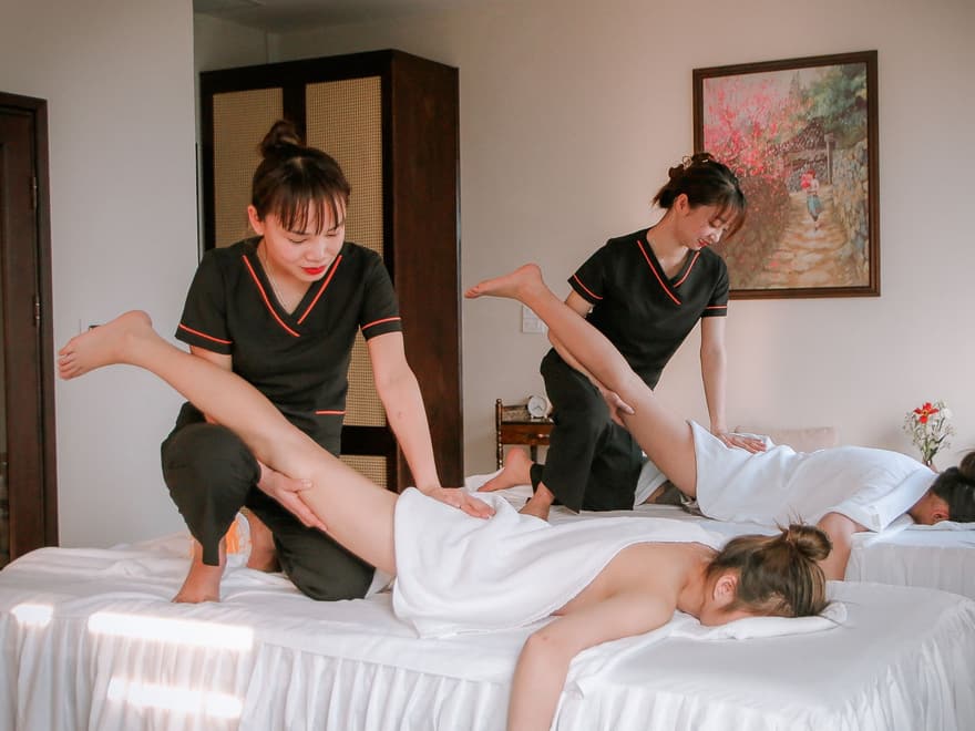 Two massage therapists treating clients in a day spa