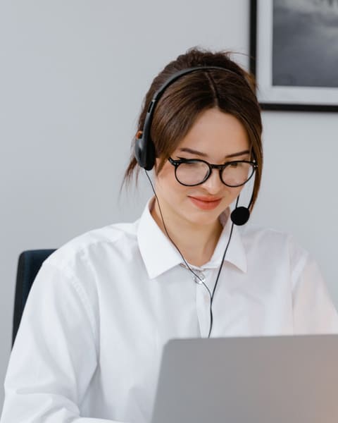 Receptionist in glasses working at a laptop