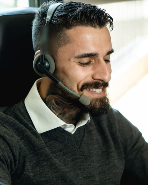 Smiling receptionist with a beard in a headset